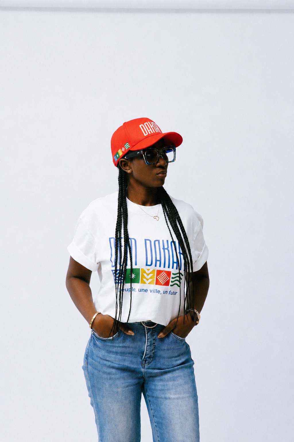 Femme portant le t-shirt DEM DAKAR blanc et la casquette DAKAR rouge
