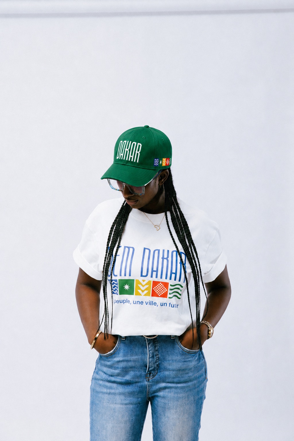 Modèle portant le t-shirt DEM DAKAR blanc et la casquette DAKAR verte